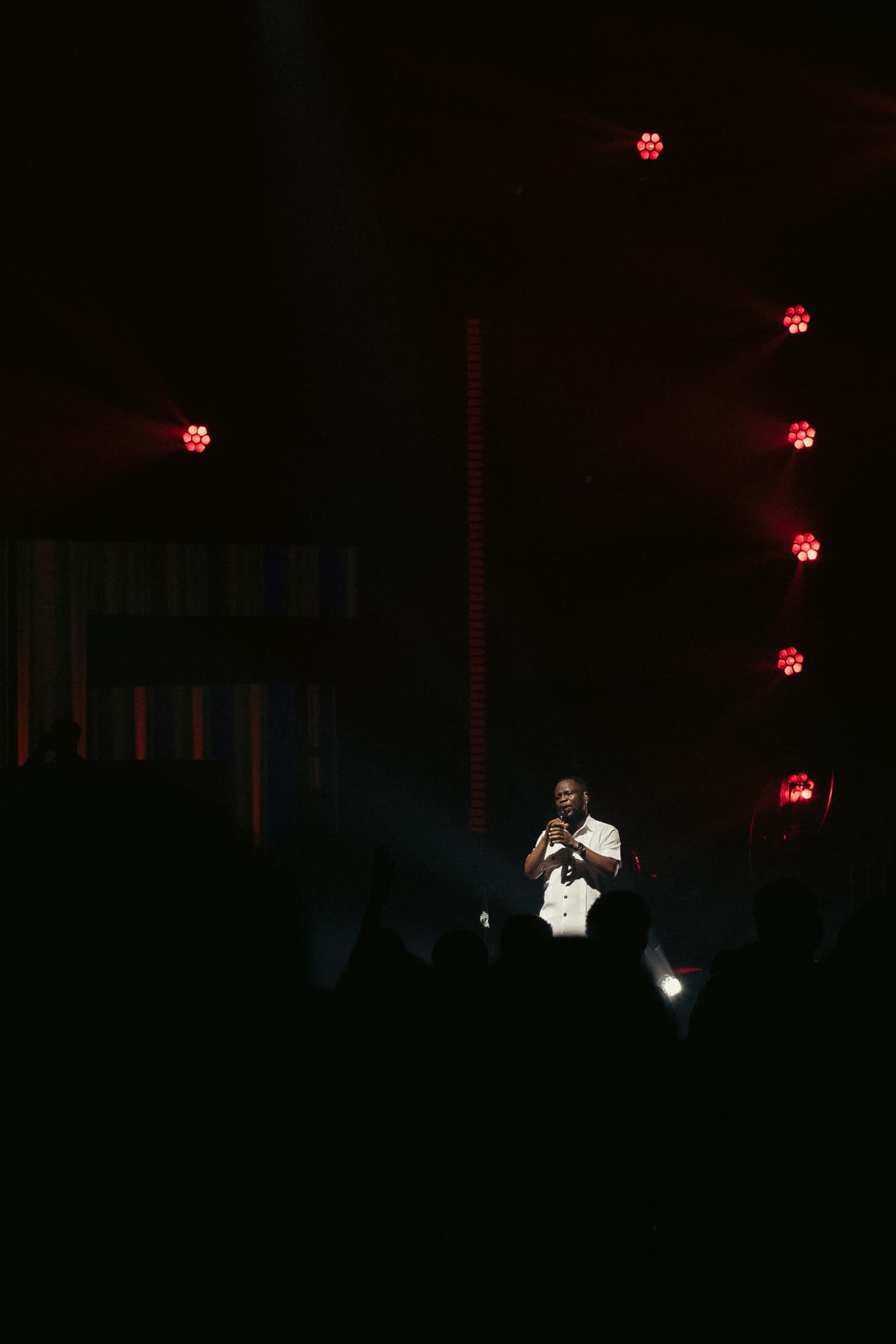 Wide stage view of Pastor Edwin Dadson leading worship